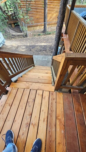 A wooden deck with a staircase leading to a covered area.