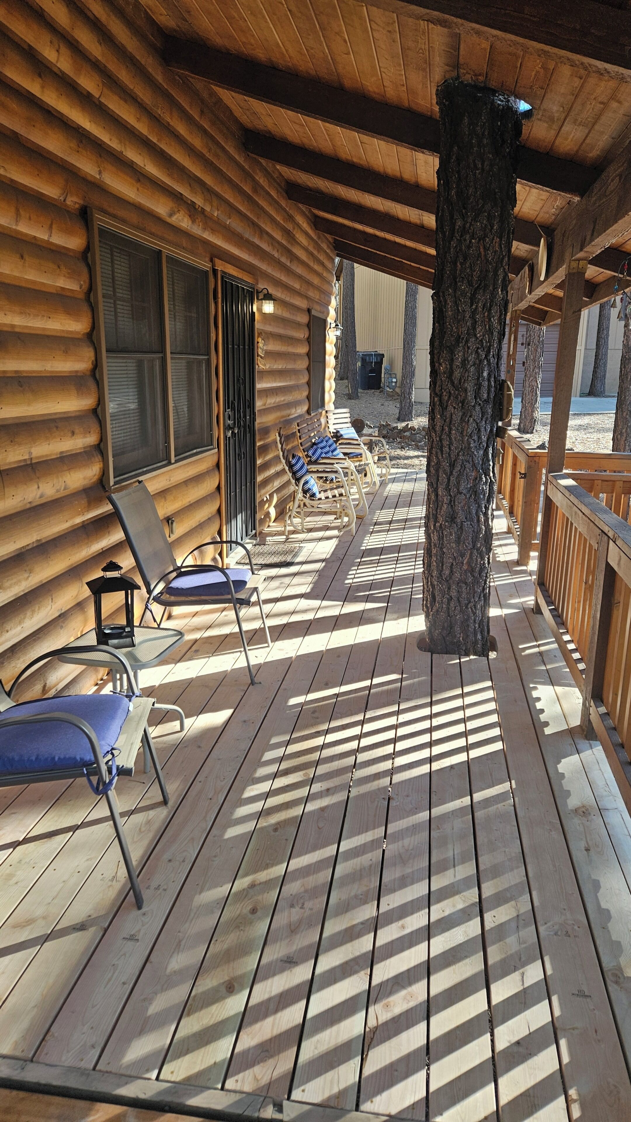Une terrasse en bois avec des chaises longues et une structure de cabane en bois.