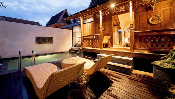 A wooden outdoor seating area with a pool, a covered wooden structure, and a stone bench. - Lanturan Ubud-Villas (Ubud)