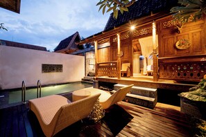 A wooden outdoor seating area with a pool, a covered wooden structure, and a stone bench. - Lanturan Ubud-Villas (Ubud)