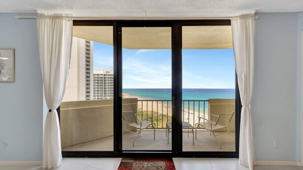Ein Balkon mit Blick auf Strand und Meer.