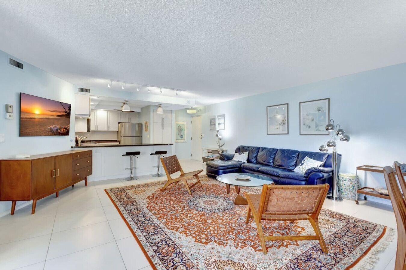 A modern living room with a blue sofa, a coffee table, and a patterned rug.