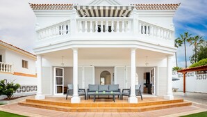 A two-story white house with a covered porch, a balcony, and a well-maintained lawn. - Exclusive Villa Olivia with Private heated Pool (Callao Salvaje)
