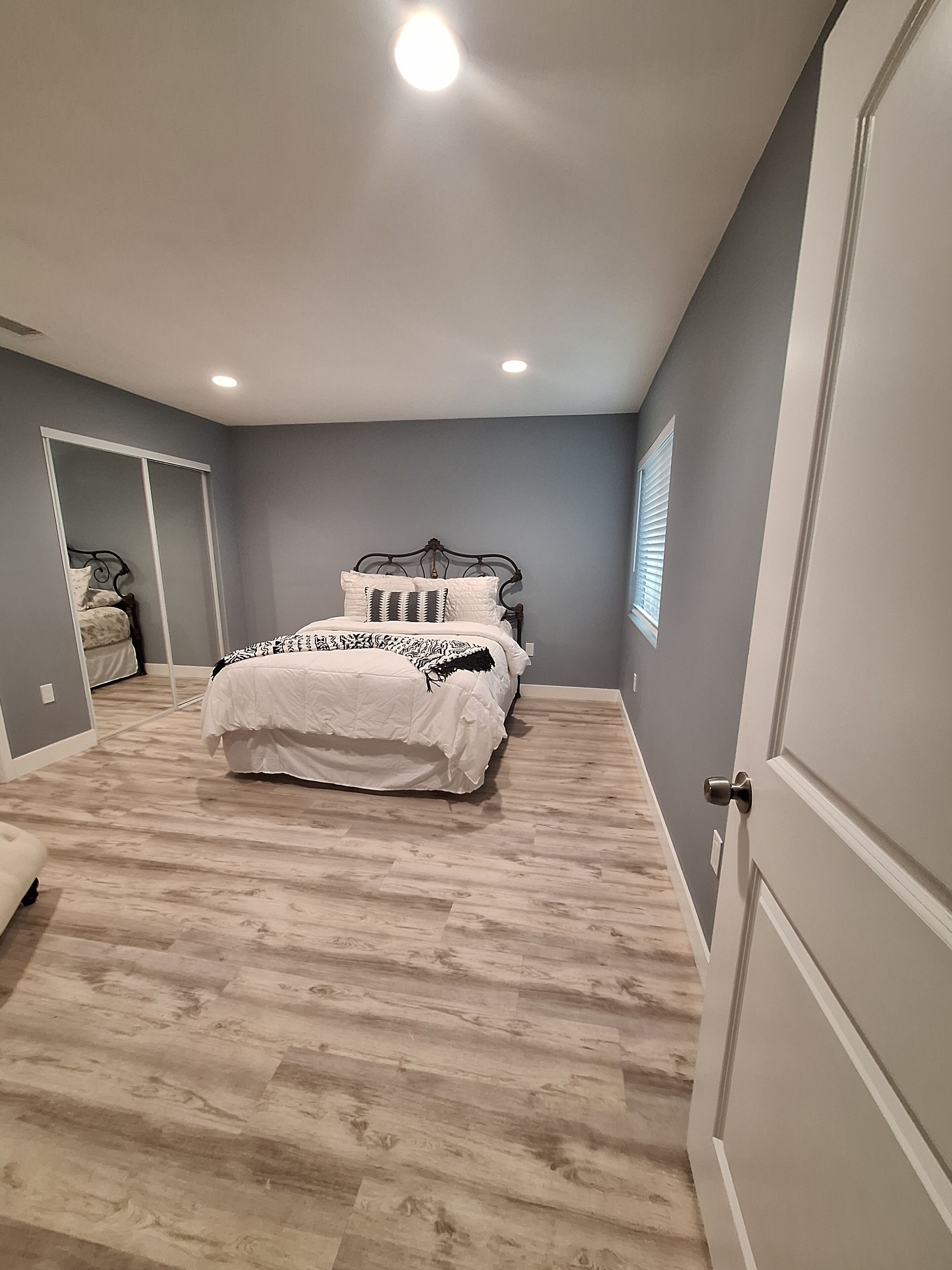 Une chambre à coucher avec un lit, une porte et une fenêtre.
