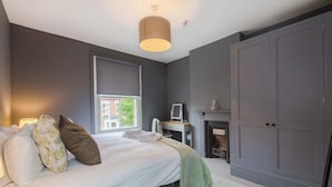A bedroom with a bed, a desk, a fireplace, and a wardrobe. - Spacious House, Private Parking & Garden (Gloucestershire)
