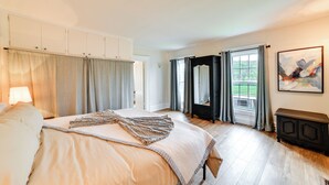 A bedroom with a large bed, a dresser, and a window with curtains. - Hike & Baseball Near Cooperstown: Home on 30 Acres (Cherry Valley)