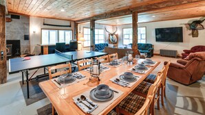 A spacious dining area with a long wooden table set for a meal, surrounded by wooden chairs. - Hike & Baseball Near Cooperstown: Home on 30 Acres (Cherry Valley)