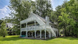 A two-story house with a balcony and a covered porch. - Spacious Riverfront Cottage w/ Dock in Green Pond! (Green Pond)