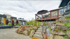 A modern building with a staircase leading to a covered outdoor area, surrounded by rocks and plants. - 2 Blocks to Beach Park: Cozy Seattle Townhome (Seattle)