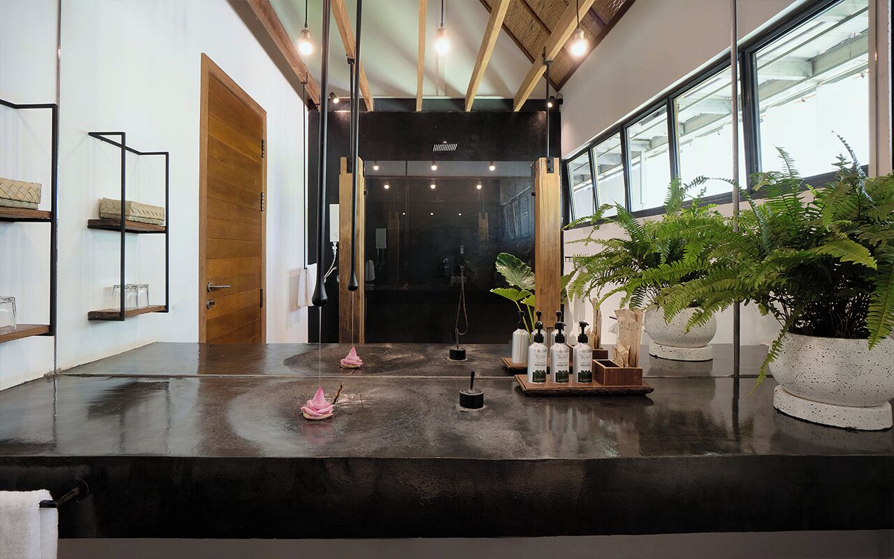 A modern reception area with a wet floor sign, wooden door, and potted plants.