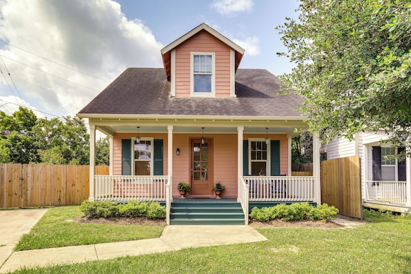 Stunning two-story home with a charming front porch and beautifully manicured lawn.