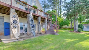 A building with a covered porch, kayaks, and a staircase leading to an upper level. - Deck & Views: Lake Murray Escape in Chapin! (Chapin)