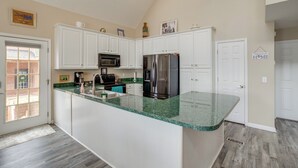 A modern kitchen with white cabinets, a green granite countertop, stainless steel appliances, and a view of the outside. - Deck & Views: Lake Murray Escape in Chapin! (Chapin)