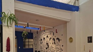 Un comedor con una mesa, sillas y un mural en la pared.