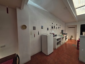 A compact kitchen with a refrigerator, a sink, and a small dining area. - Cozy Town House Ixim - 15 mins walk to Central Park (Antigua Guatemala)