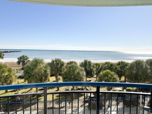 A balcony with a view of the beach, palm trees, and a pier in the distance. - Low Tide Loft/Premium Location (Myrtle Beach)