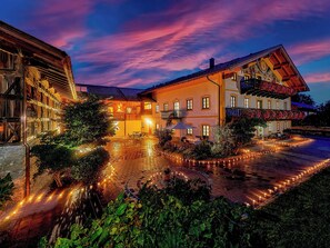 A traditional building with a courtyard, outdoor seating, and a well-lit entrance.