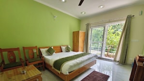 Un dormitorio con cama, muebles de madera, una ventana con cortinas y vistas a zonas verdes.
