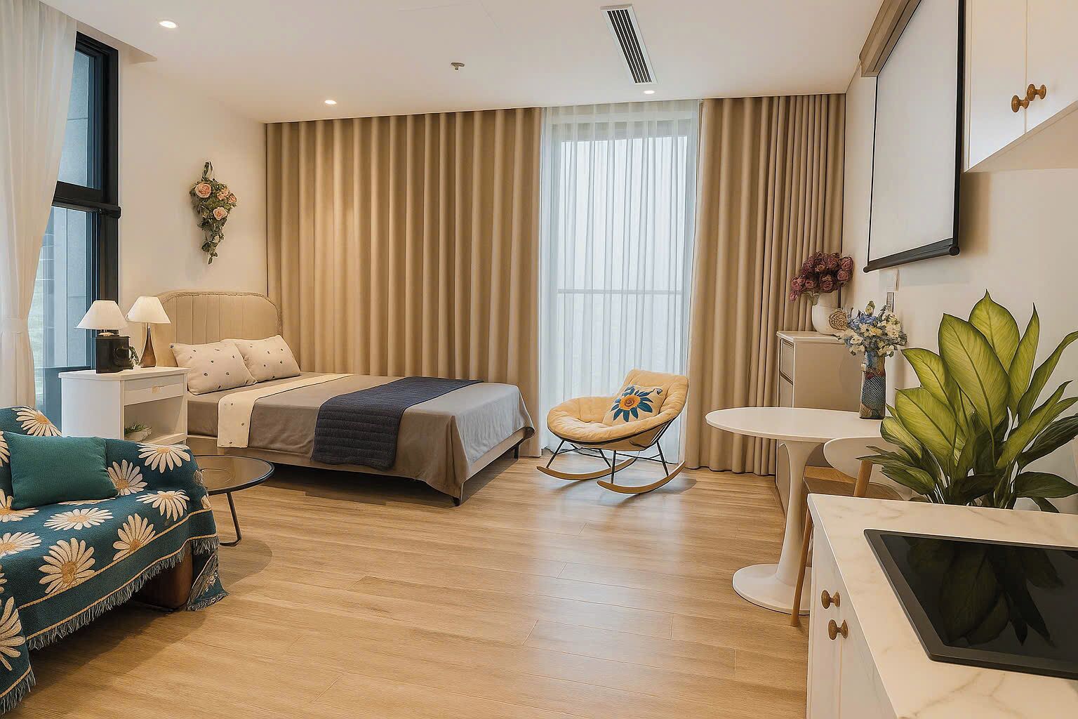 Una camera d'albergo con un letto, una poltrona a dondolo, un tavolino e una pianta in vaso.