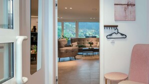 Un salon moderne avec un canapé, une table basse et un porte-manteau suspendu.