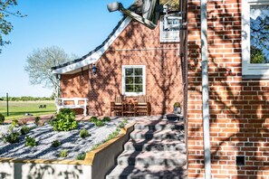 Una casa in mattoni con portico, una finestra e un'antenna parabolica.