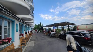 A seaside hotel with outdoor seating, a covered area, and a view of the sea. - Room 'Suite Mit Seeblick U Balkon' with Lake View, Shared Terrace and Wi-Fi (Reichenau)