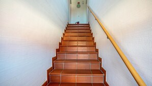Una escalera con barandilla de madera que da a una plataforma.