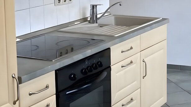 Une cuisine équipée d’une cuisinière, d’un four et de placards.