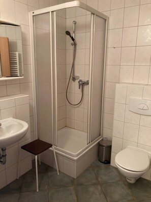 Un baño con ducha, lavabo e inodoro.