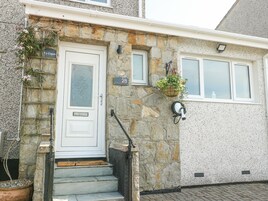 A stone house with a white door, numbered 28, and a small window above the door.