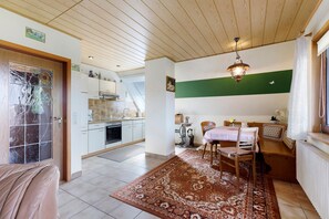 Una habitación con comedor, cocina y vistas al exterior.