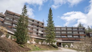 A multi-story building with balconies, a covered walkway, and surrounding greenery. - Apartment 'Terrassenpark 160' with Mountain View, Balcony and Wi-Fi (Schonach)