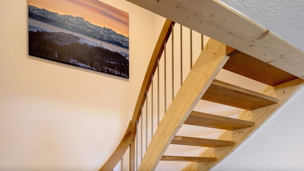Eine Holztreppe mit Blick auf eine Berglandschaft und einen See.