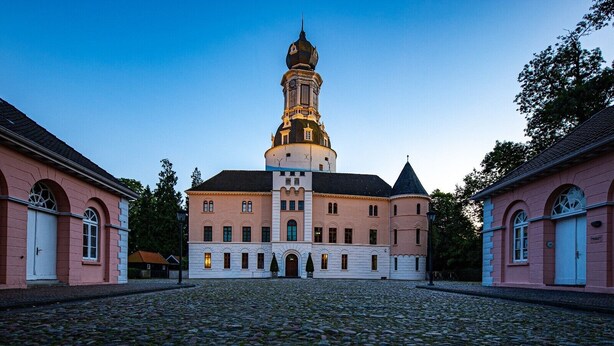 A historic building with a prominent tower, a courtyard, and symmetrical architecture. - Modern apartment in the city center of Jever (Jever)