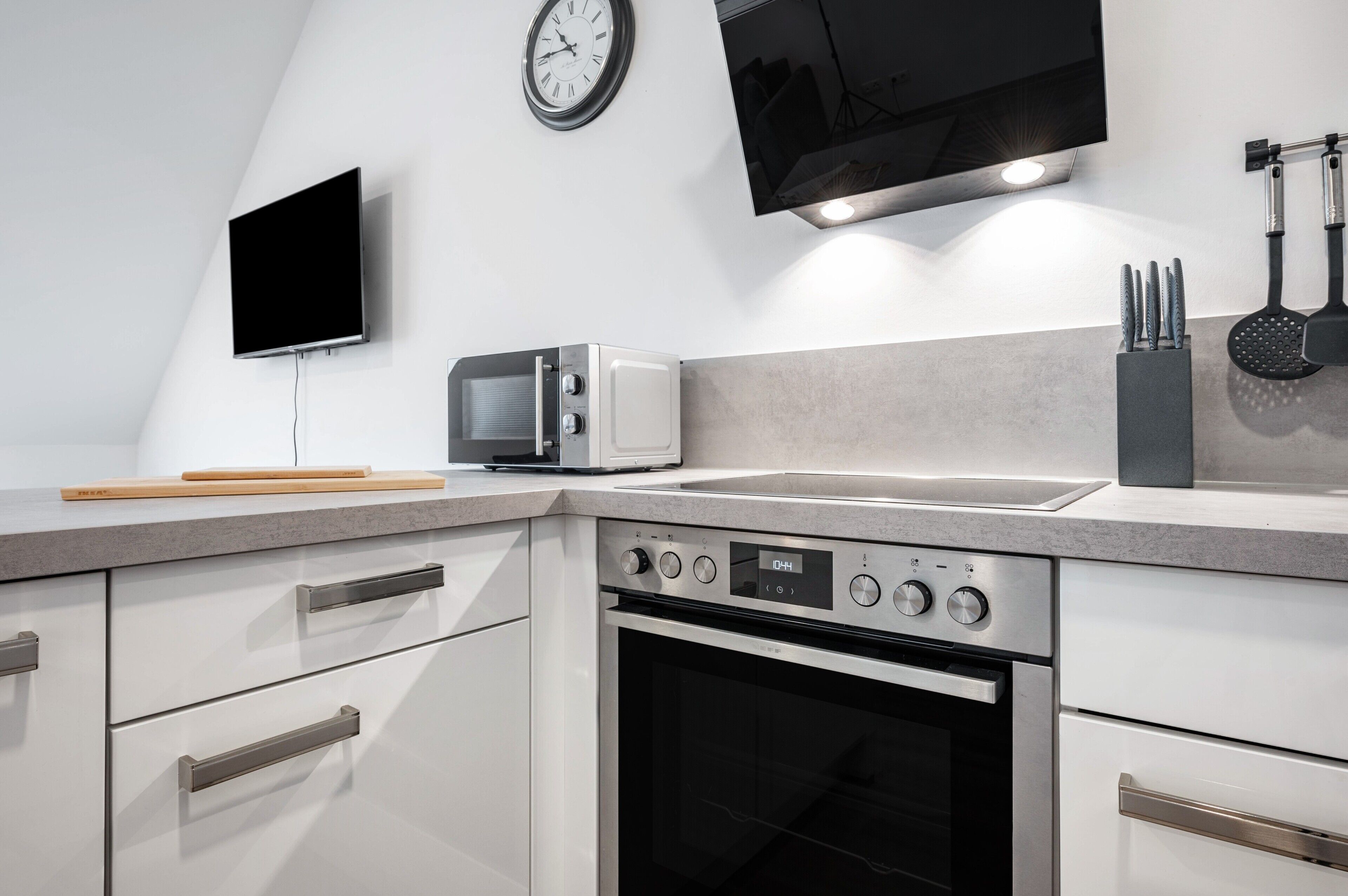 Een moderne keuken met een inbouwoven, een magnetron en een spoelbak.
