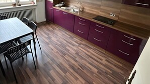 Een moderne keuken met een eettafel en stoelen, een plafondventilator en een raam met uitzicht.