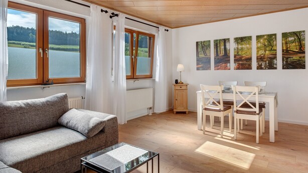 Une pièce comprenant un canapé, une table à manger, des chaises et des œuvres d’art accrochées au mur.