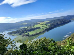 Una vista panorámica de un lago rodeado de campos verdes y colinas.