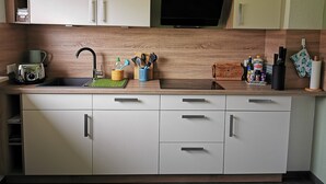 A modern kitchen with a built-in microwave, a sink, and a wooden countertop.
