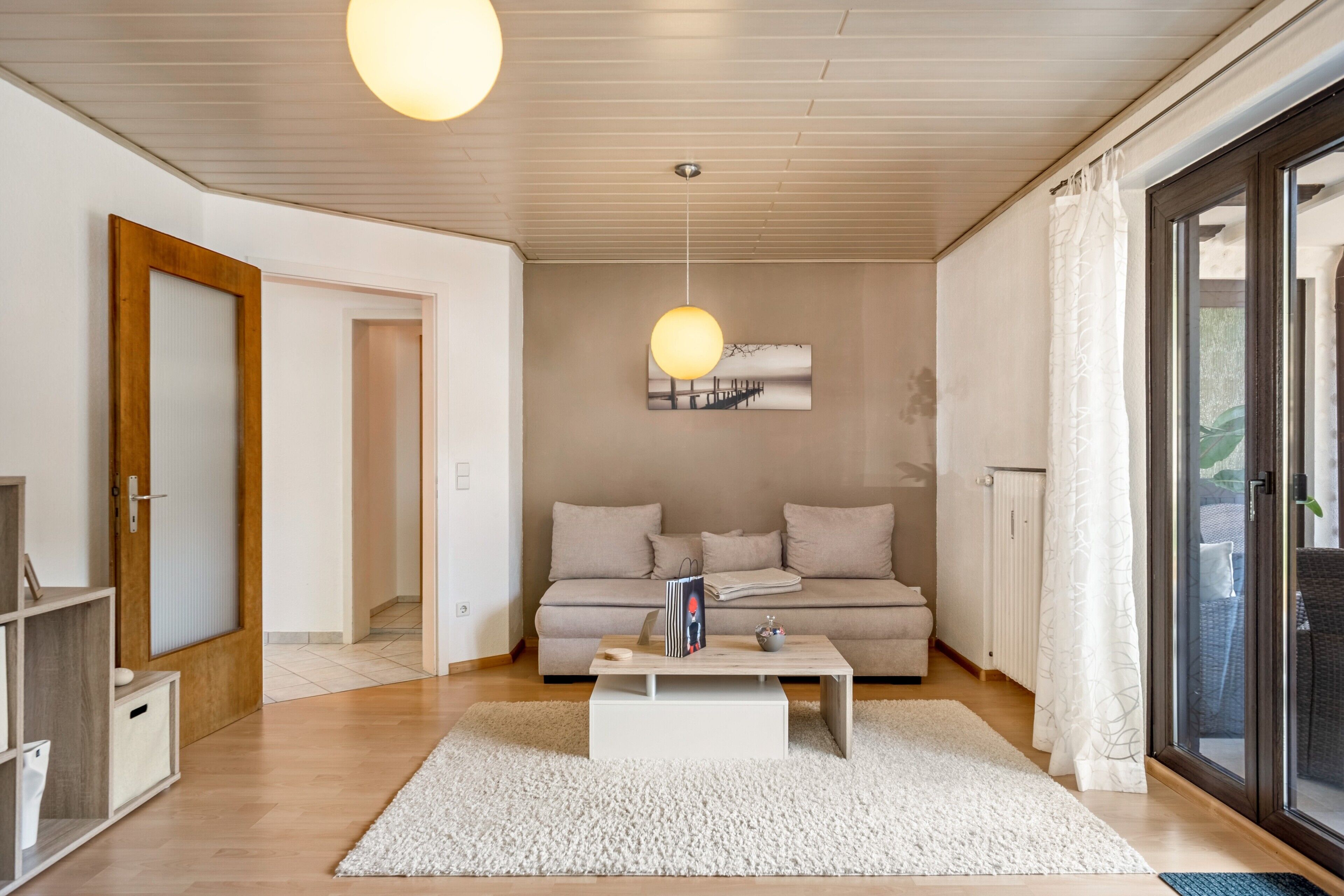 Una sala de estar moderna con un sofá, una mesa de centro y una lámpara colgante.