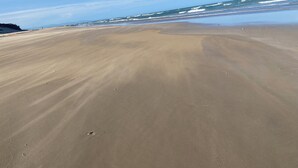 A sandy beach with gentle waves and a clear sky. - Peaceful escape in the coast of Paradise beach, Jeffreys Bay, South Africa (Jeffreys Bay)