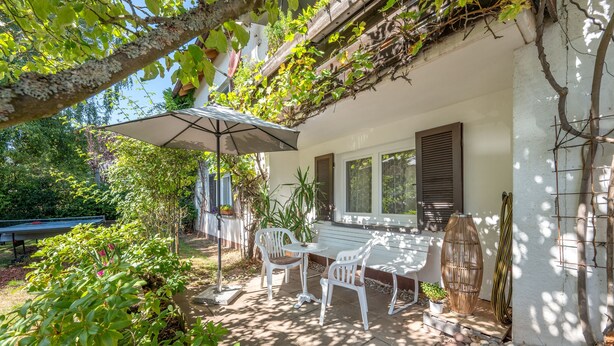 An outdoor patio with a table and chairs, a pergola with climbing plants, and a view of the garden. - Apartment 'Haus Zur Bienenweide' with Shared Terrace, Balcony and Wi-Fi (Schömberg)