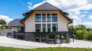 A modern two-story house with a sloped roof, large windows, and a paved driveway. - Holiday Apartment 'Spatzennest' with Mountain View, Balcony and Wi-Fi (Dachsberg (Südschwarzwald))