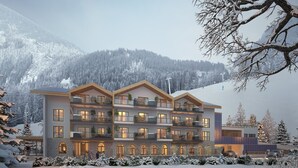 A multi-story hotel with balconies, large windows, and a view of snow-covered mountains. - Apartment in Berwang with Ski-In/Ski-Out (Berwang)