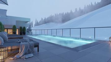 A modern outdoor pool area with a glass barrier, seating, and a view of a snowy mountain.