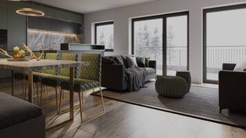 Ein modernes Wohnzimmer mit einer Couch, Hocker und einem Essbereich mit Stühlen und einem Tisch.