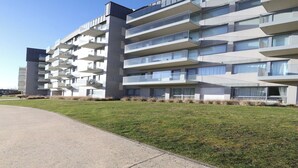 Un immeuble moderne à plusieurs étages, doté de balcons et de grandes fenêtres.
