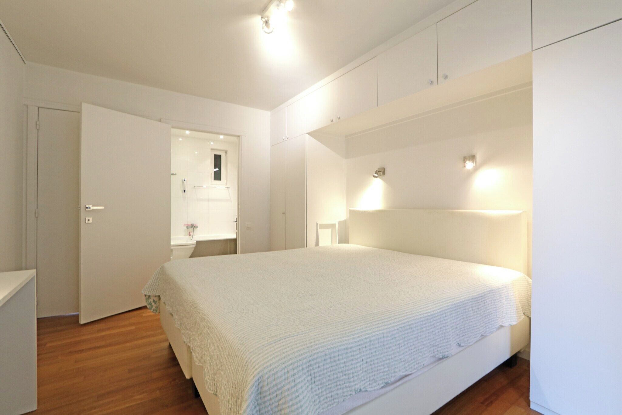 Ein Schlafzimmer mit einem großen Bett, einem Kleiderschrank und einer Tür zum Badezimmer.