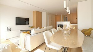 Ein modernes Wohnzimmer mit Sofa, Esstisch und Küchenzeile.