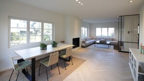 Amplia sala de estar con mesa de comedor, sillas, sofá y chimenea.